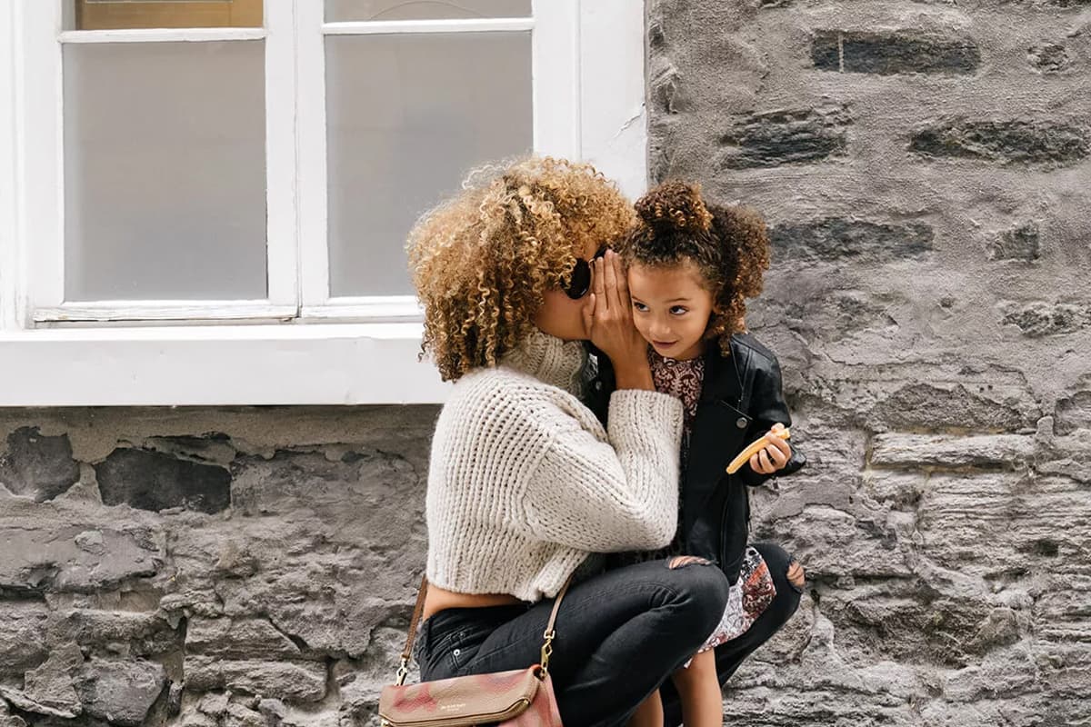 woman whispering to child