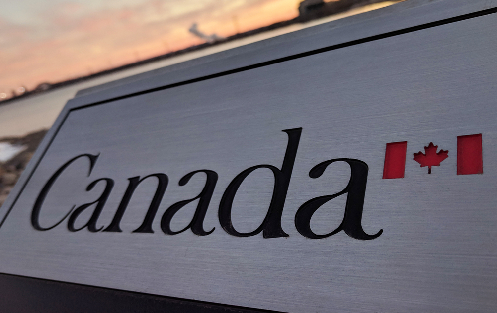 A close-up, slightly low-angle shot of a brushed silver or metallic sign with the word 