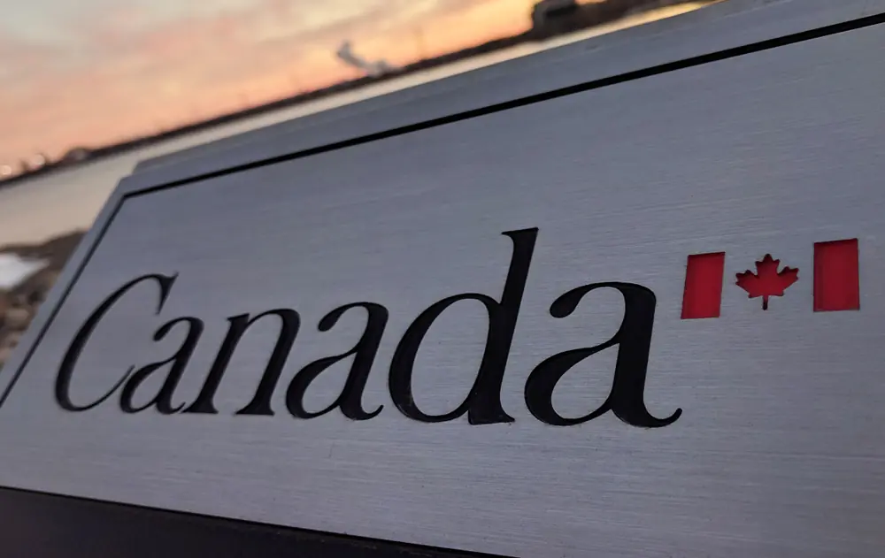 A close-up, slightly low-angle shot of a brushed silver or metallic sign with the word 